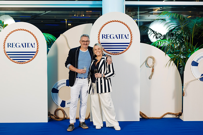 Mike&Meredith_MEETINGS 2025 Custom corporate event design and styling for the "Regatta!" themed Gala Dinner, featuring a white arch photo backdrop with nautical elements, lifebuoys, and tropical greenery.